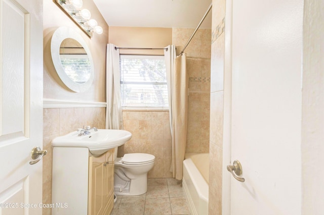 bathroom with toilet, shower / bath combo, wainscoting, vanity, and tile patterned flooring