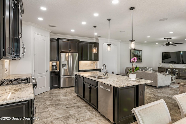 kitchen featuring open floor plan, appliances with stainless steel finishes, a ceiling fan, and a sink