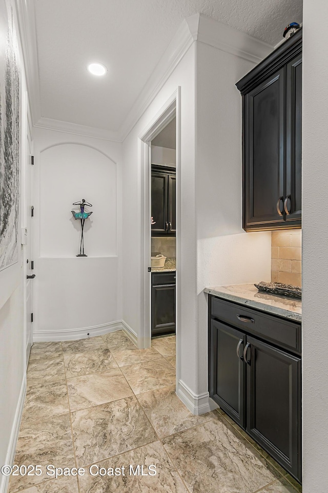 hallway featuring crown molding and baseboards