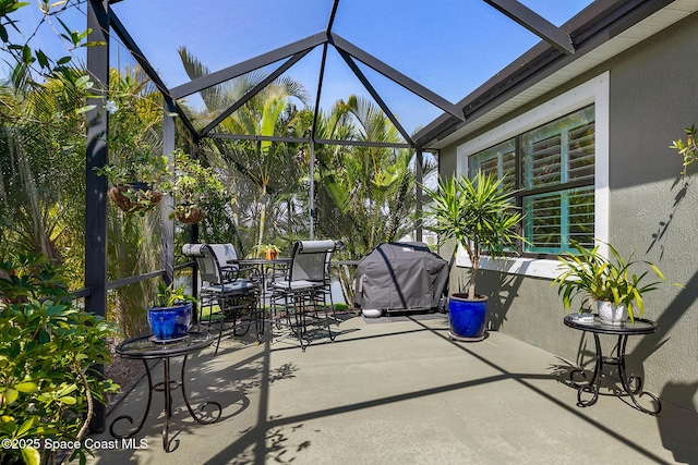 view of patio / terrace with glass enclosure, area for grilling, and outdoor dining space