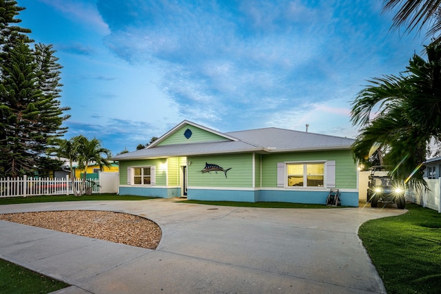 view of front of home with concrete driveway, a gate, fence, and stucco siding