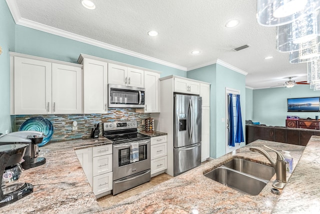 303 Harrison Ave, Cape Canaveral, FL 32920 - kitchen featuring visible vents, a sink, stainless steel appliances, white cabinetry, and backsplash