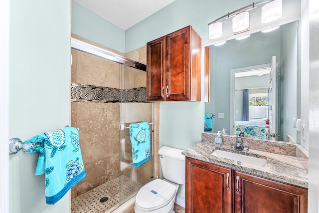 303 Harrison Ave, Cape Canaveral, FL 32920 - ensuite bathroom with vanity, a shower stall, ensuite bathroom, a textured ceiling, and toilet