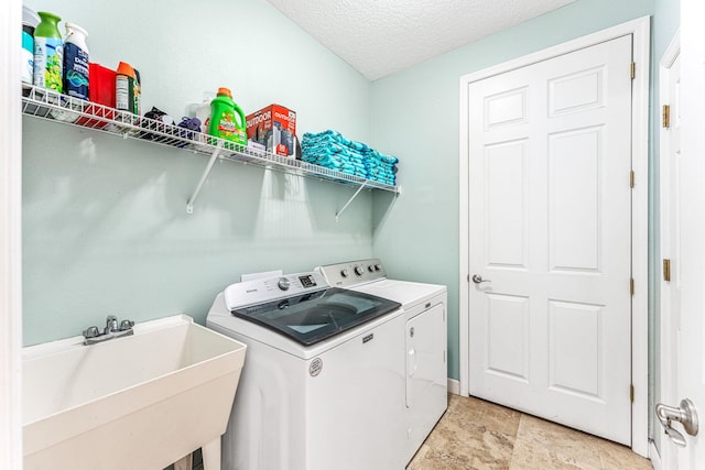 303 Harrison Ave, Cape Canaveral, FL 32920 - clothes washing area featuring a textured ceiling, laundry area, washer and clothes dryer, and a sink
