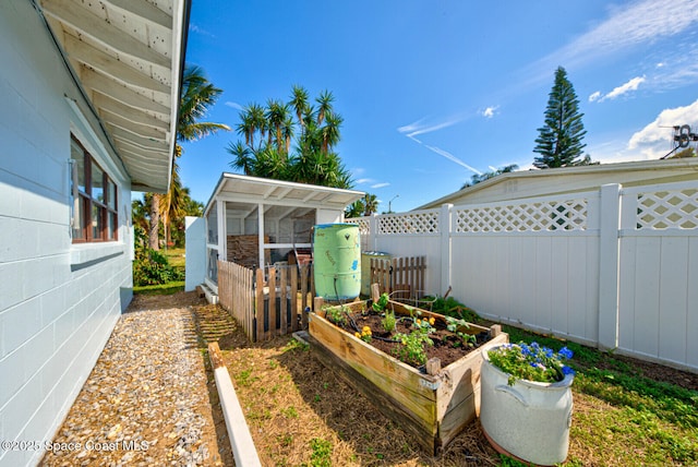 view of yard featuring fence, a vegetable garden, and an outbuilding