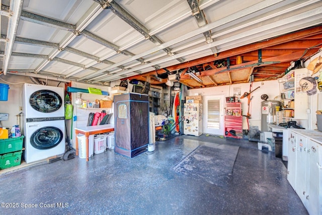 garage featuring water heater, freestanding refrigerator, and stacked washer and clothes dryer