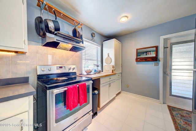 kitchen featuring baseboards, stainless steel electric range oven, light countertops, white cabinetry, and backsplash