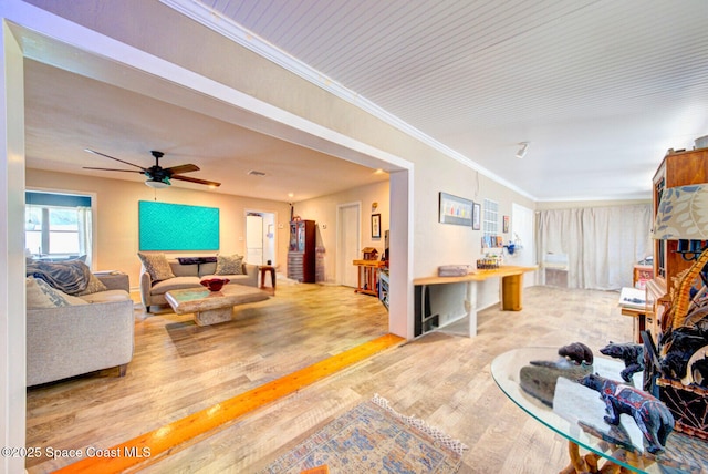 living area featuring ornamental molding, ceiling fan, and wood finished floors