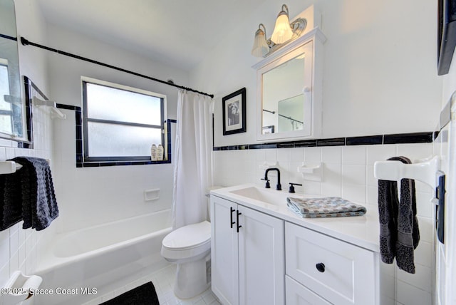 bathroom with tile walls, toilet, shower / bath combo with shower curtain, vanity, and tile patterned flooring