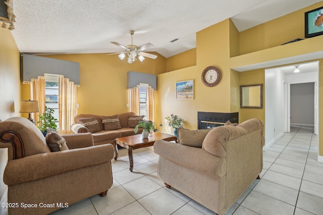 living room featuring vaulted ceiling, ceiling fan, a textured ceiling, and a wealth of natural light