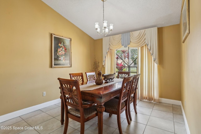 dining area with light tile patterned floors, baseboards, a chandelier, and vaulted ceiling