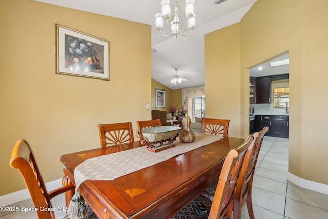 dining room with lofted ceiling, ceiling fan with notable chandelier, light tile patterned flooring, and baseboards