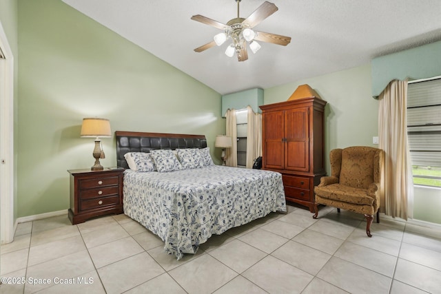 bedroom with lofted ceiling, light tile patterned flooring, ceiling fan, and baseboards