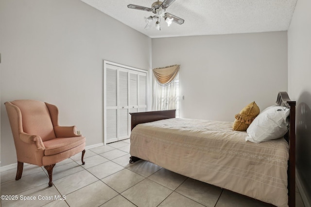 bedroom featuring a textured ceiling, light tile patterned flooring, baseboards, vaulted ceiling, and a closet