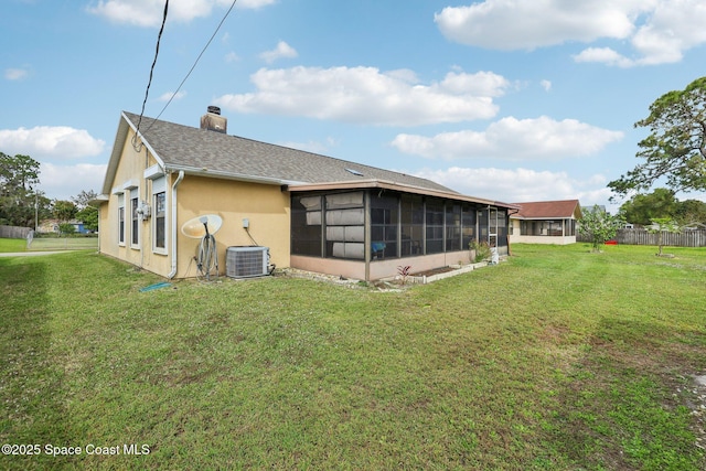 rear view of property featuring a yard, a chimney, stucco siding, a shingled roof, and a sunroom