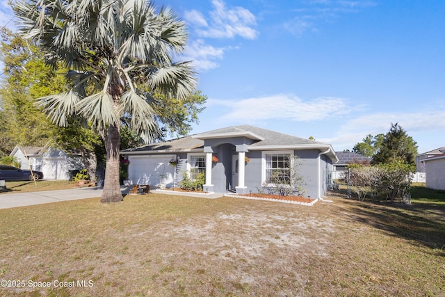 view of front of house with stucco siding, a front yard, concrete driveway, and an attached garage