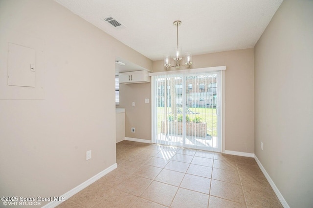 empty room featuring light tile patterned floors, baseboards, visible vents, and a chandelier