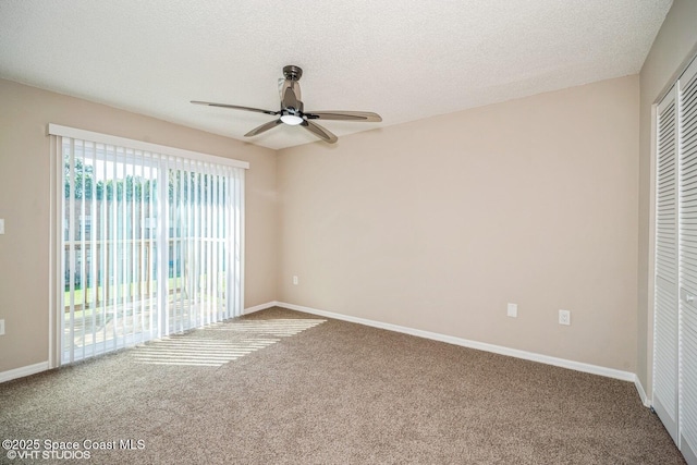 spare room with a textured ceiling, carpet flooring, a ceiling fan, and baseboards