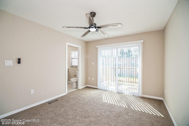 unfurnished room featuring carpet, a textured ceiling, visible vents, and baseboards