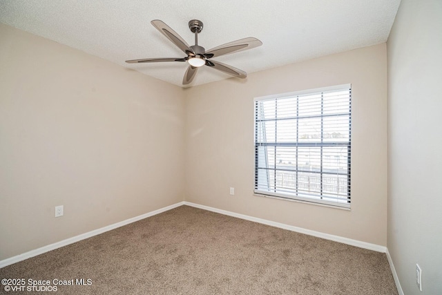 empty room with a textured ceiling, baseboards, a ceiling fan, and carpet flooring