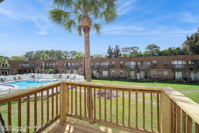 wooden terrace featuring a residential view, a community pool, and a yard