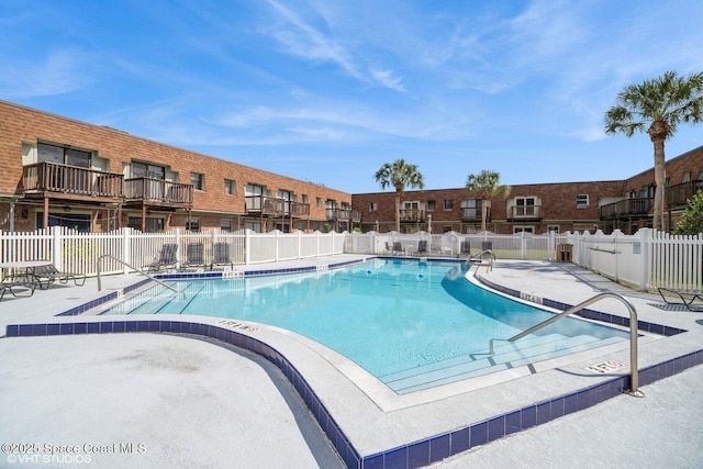 community pool featuring a patio area and fence