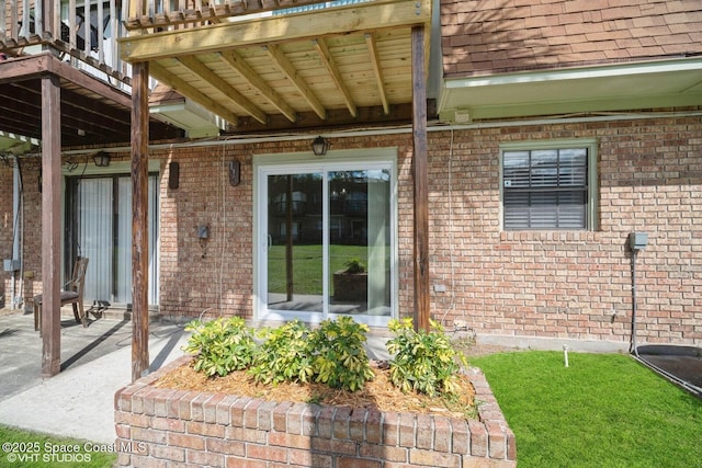 exterior space featuring brick siding and roof with shingles