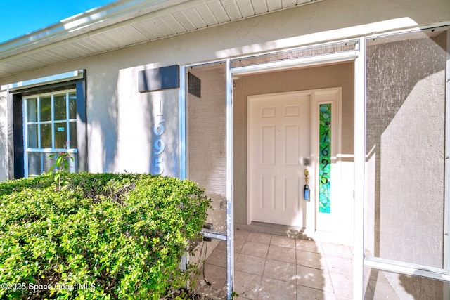 doorway to property featuring stucco siding