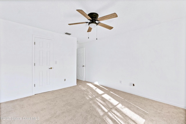 spare room with carpet, visible vents, and ceiling fan