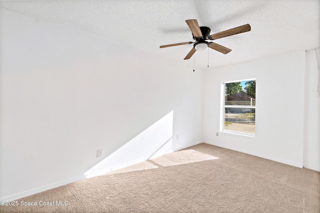 empty room with a textured ceiling, ceiling fan, and carpet