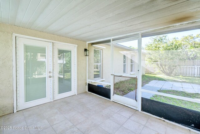 unfurnished sunroom with wood ceiling and a healthy amount of sunlight