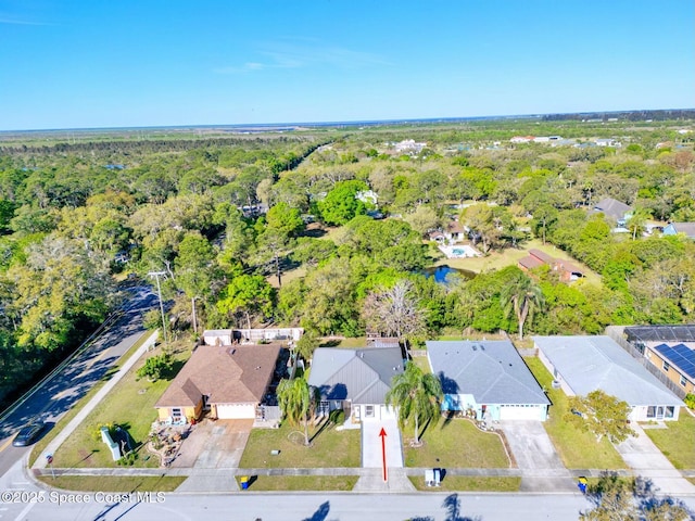 drone / aerial view with a residential view and a view of trees