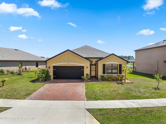 view of front facade featuring a shingled roof, an attached garage, decorative driveway, a front yard, and stucco siding