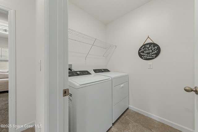 washroom with laundry area, baseboards, and washer and dryer