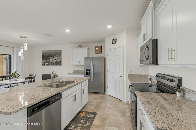 kitchen featuring a center island with sink, recessed lighting, appliances with stainless steel finishes, white cabinets, and a sink