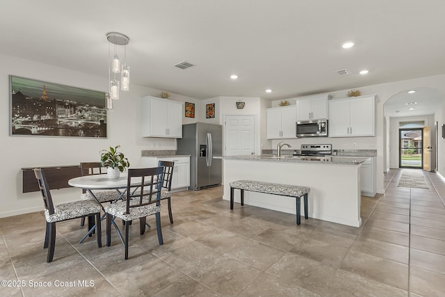 dining space with baseboards, visible vents, arched walkways, and recessed lighting