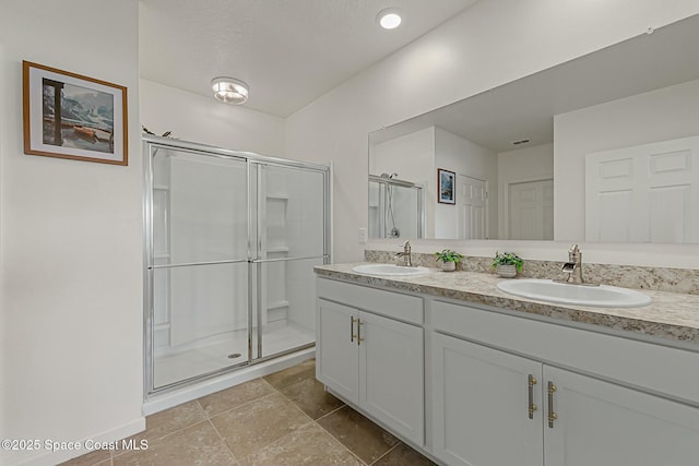 bathroom featuring double vanity, a sink, visible vents, and a shower stall