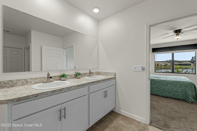 bathroom with double vanity, a ceiling fan, baseboards, and a sink