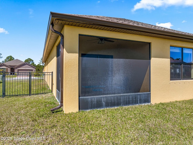 view of home's exterior with a yard, fence, and stucco siding