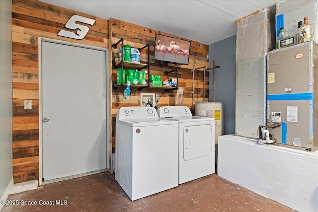 washroom with wood walls, laundry area, separate washer and dryer, and electric water heater