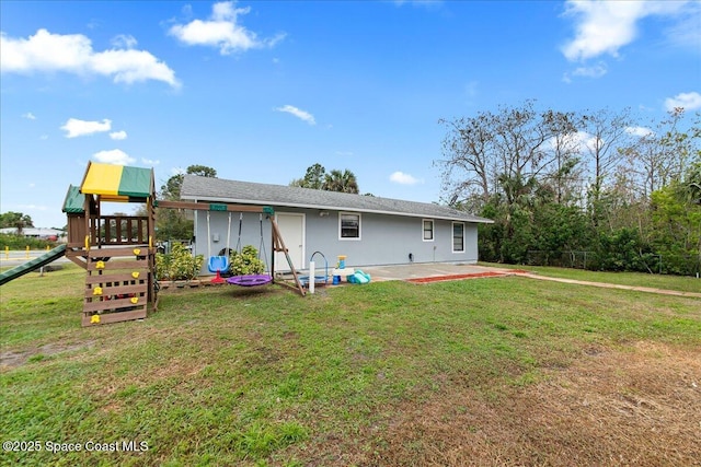 rear view of house featuring a patio area, a playground, a lawn, and stucco siding