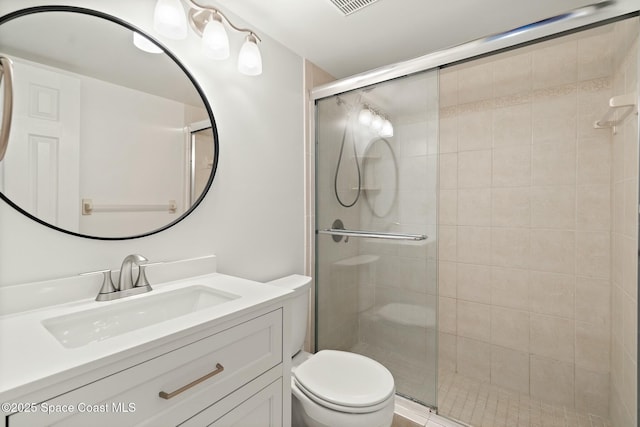 bathroom with vanity, a shower stall, and toilet