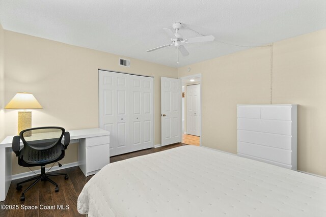 bedroom featuring dark wood-style flooring, a closet, visible vents, a ceiling fan, and baseboards