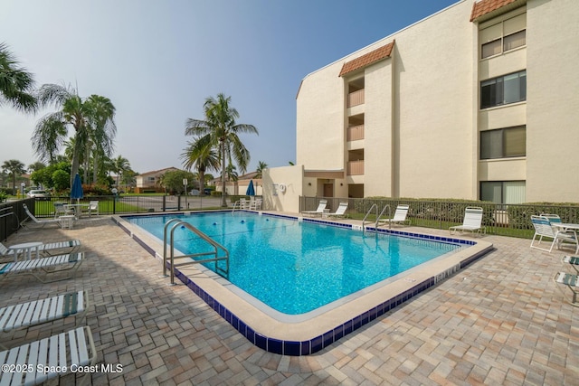 community pool featuring fence and a patio