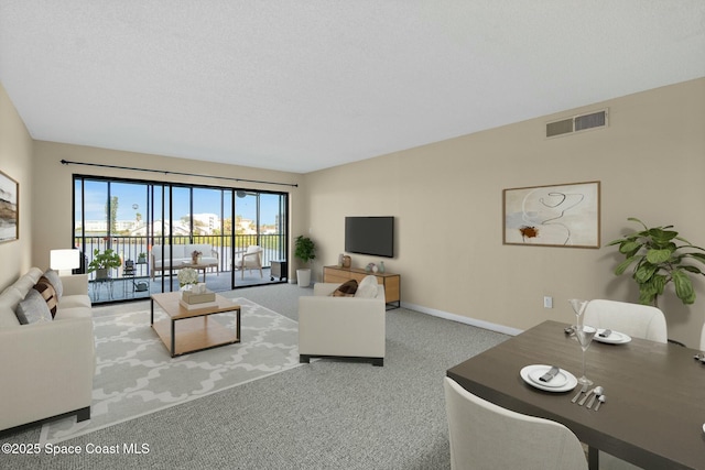 carpeted living area with baseboards and visible vents