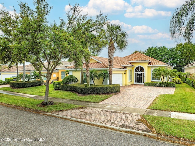 view of front facade featuring stucco siding, driveway, and a front yard