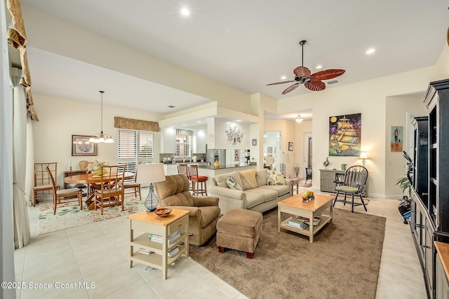 living room with light tile patterned floors, visible vents, baseboards, recessed lighting, and ceiling fan with notable chandelier