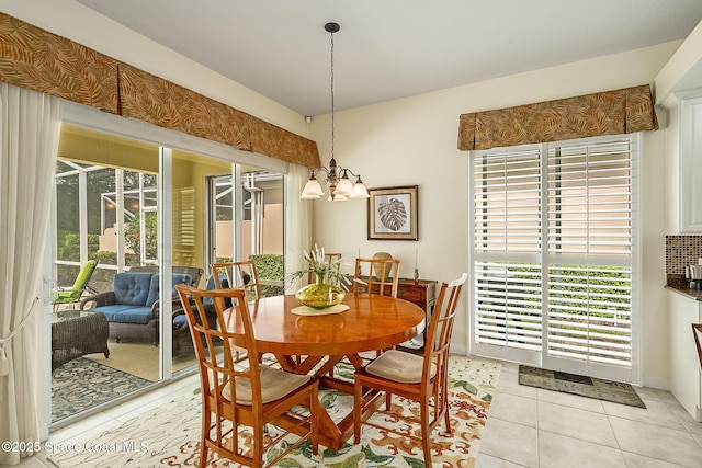 dining room with light tile patterned floors and an inviting chandelier