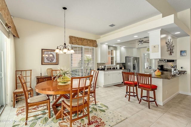 dining space featuring visible vents, light tile patterned flooring, a fireplace, baseboards, and ceiling fan