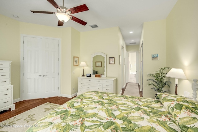 bedroom featuring wood finished floors, visible vents, a closet, and baseboards